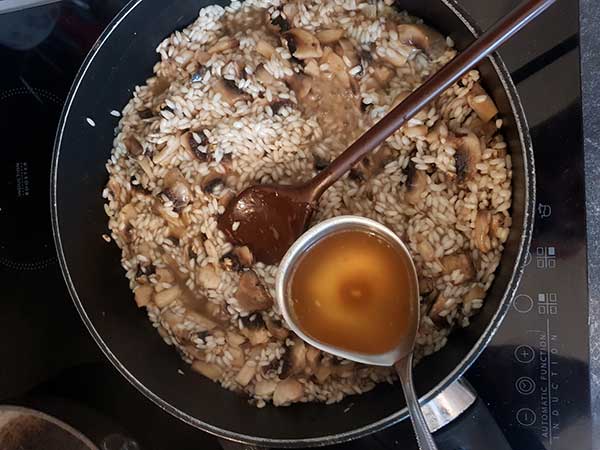 incorporer le bouillon au riz à risotto