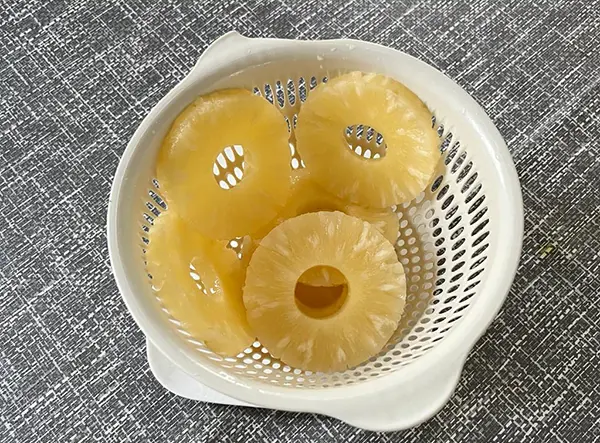 Égoutter les tranches d'ananas.