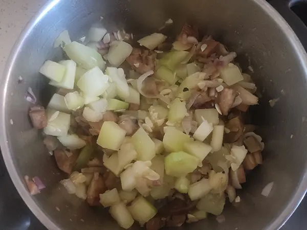 Verser les courgettes dans la casserole, avec les aubergines/oignons