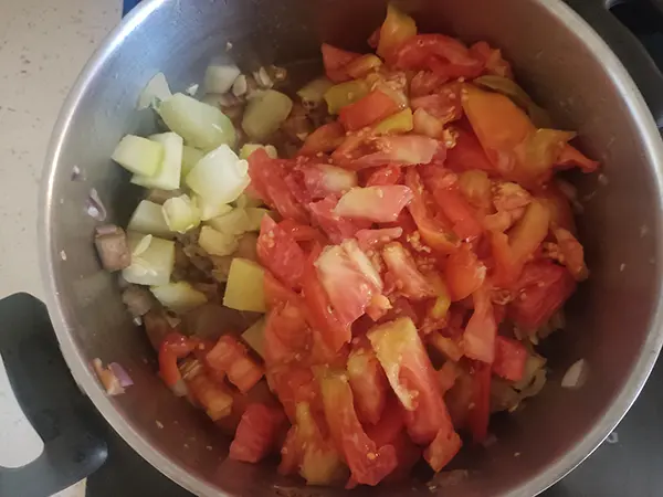 Verser les tomates dans la casserole, avec les courgette/aubergines/oignons