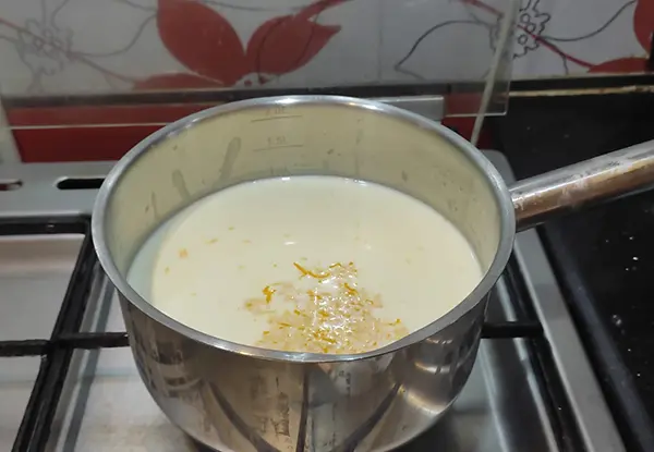Faire bouillir le lait avec le zeste d’orange.