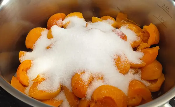 Verser les abricots et le sucre dans le récipient.
