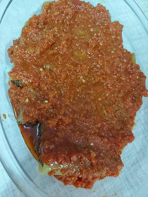 deuxième couche de sauce tomate sur les cannellonis farcis